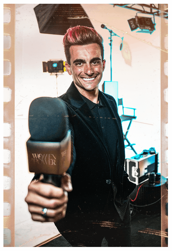 A charismatic presenter smiles while holding a microphone toward the camera, captured in a stylized "film strip" frame on a professional studio set.
