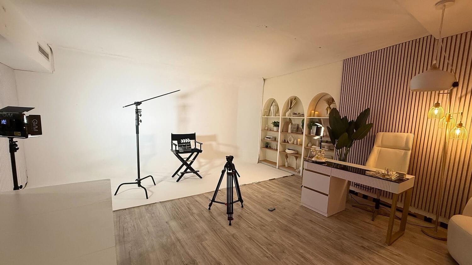 A charismatic male presenter smiles confidently in a professional studio, holding a "Women in Power" branded microphone toward the audience. The stylized film-strip border emphasizes a high-energy, behind-the-scenes look at professional media production.